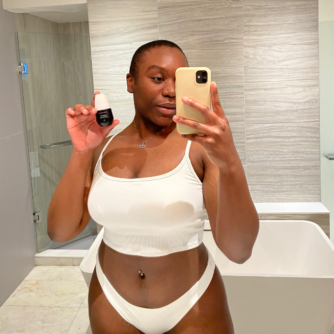 Black Woman Holding Sweet Escape Oil for Ingrown Hairs and Razor Burn